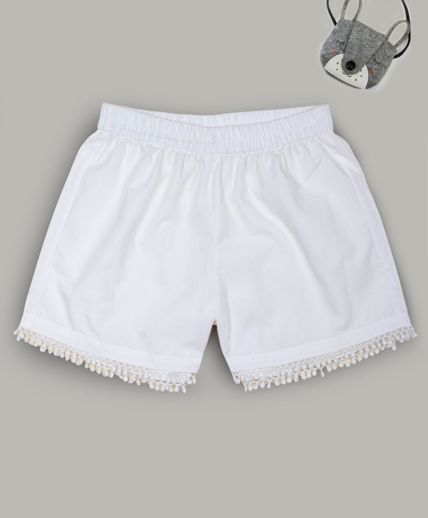 Solid White shorts with pom pom lace detailing at the bottom