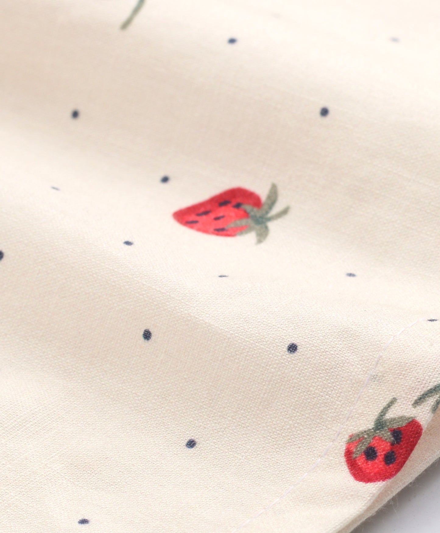 White top with strawberry and dot print with black bow tie at neck
