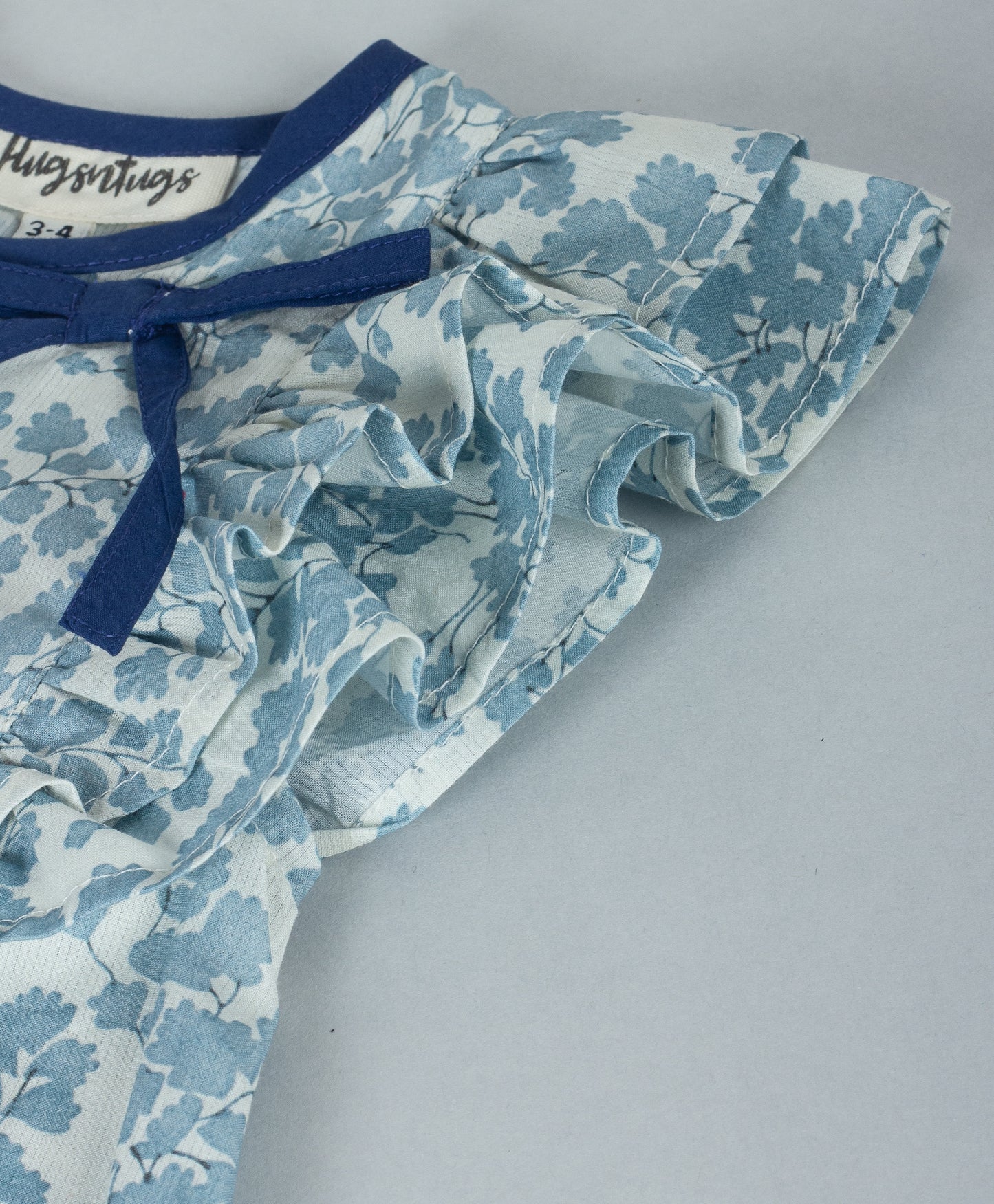 SOFT BLUE ALL OVER LEAF PRINT TOP WITH NAVY NECK BINDING AND TIE UP