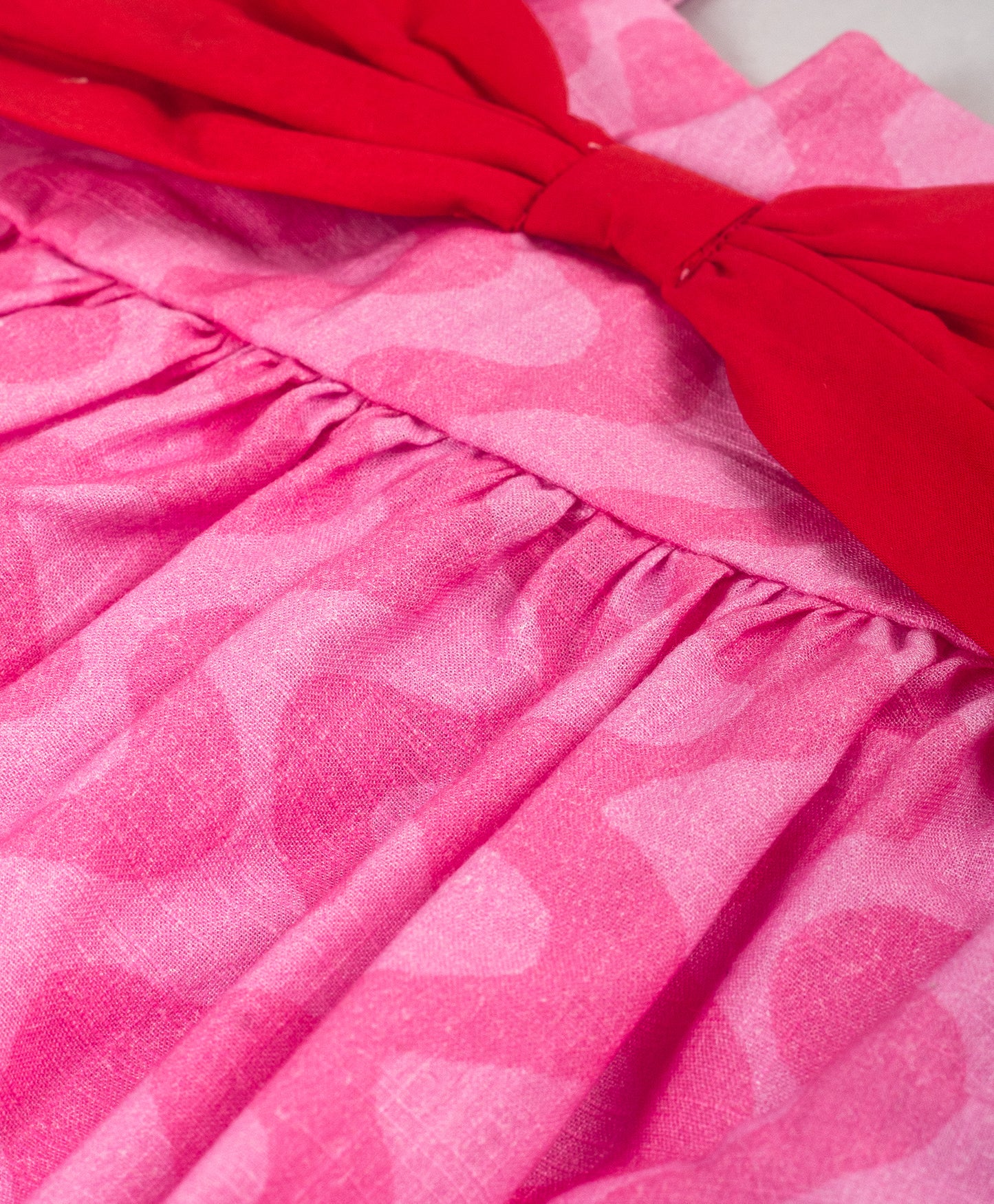 PINK SELF WAVE PRINT DRESS WITH RED BOW