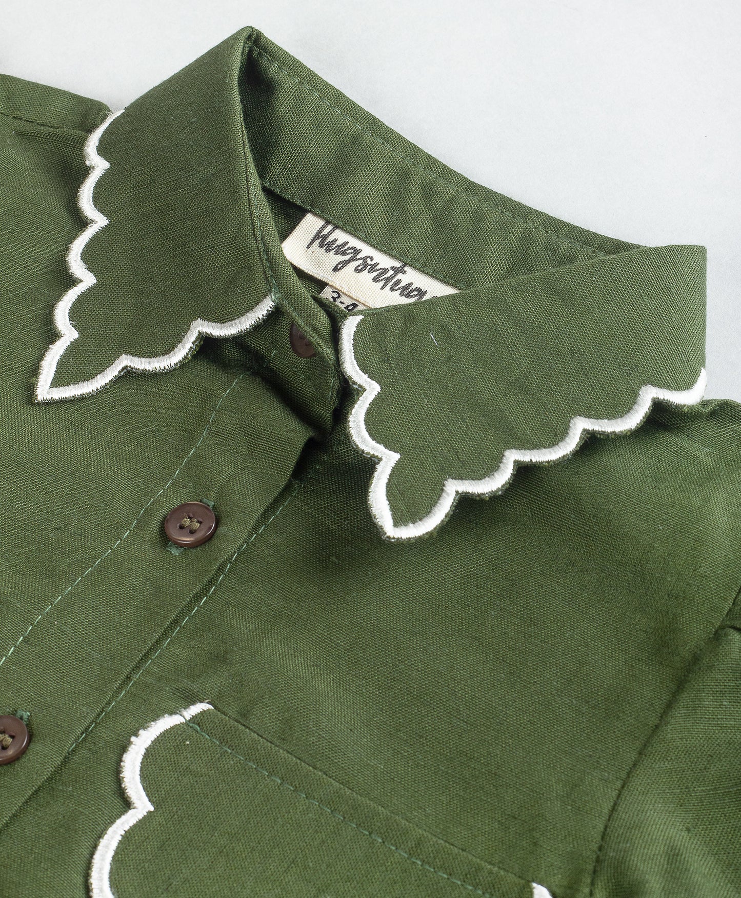 SOLID GREEN TOP WITH SCALLOPING AT COLLAR AND POCKET FLAPS