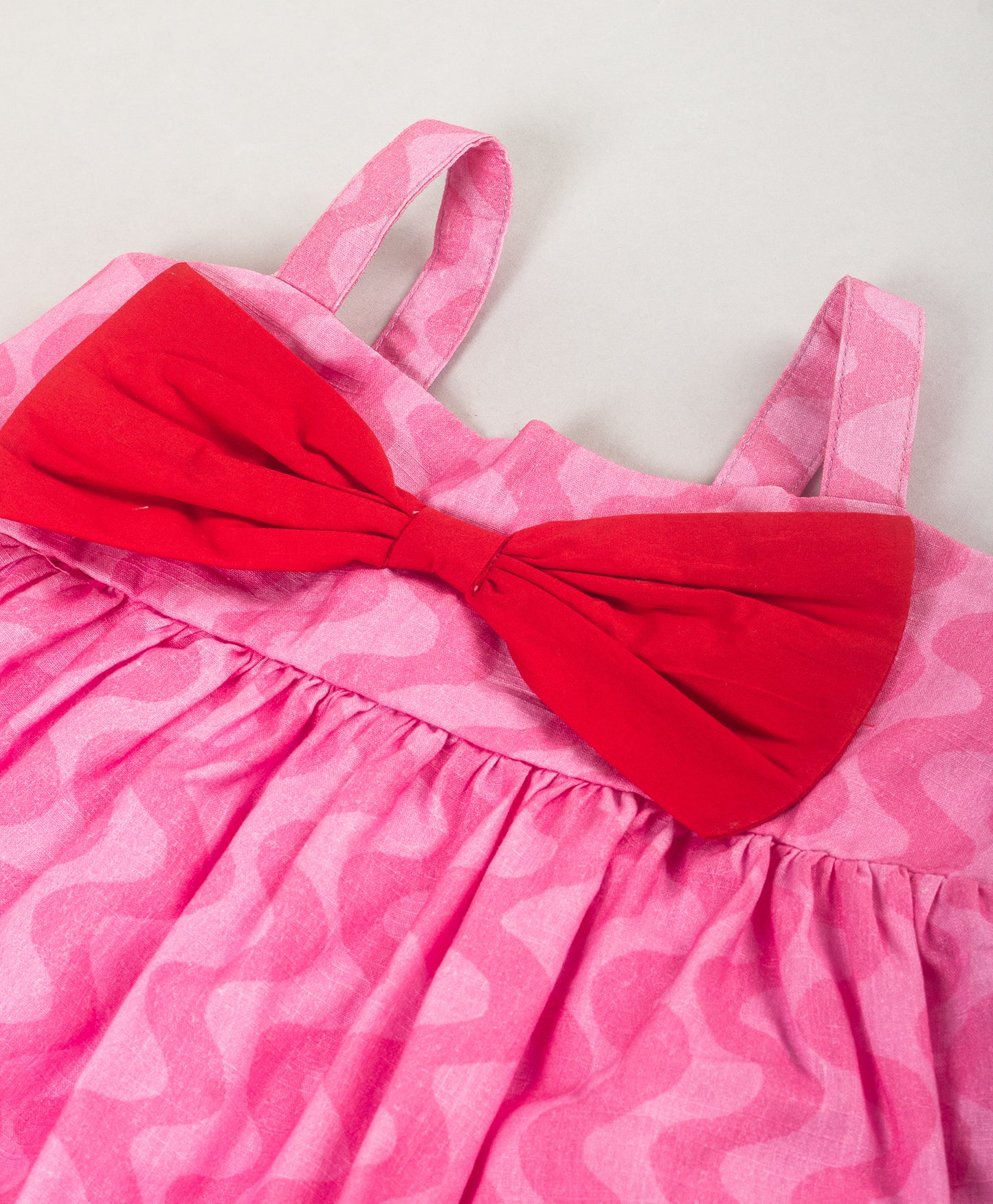 PINK SELF WAVE PRINT DRESS WITH RED BOW