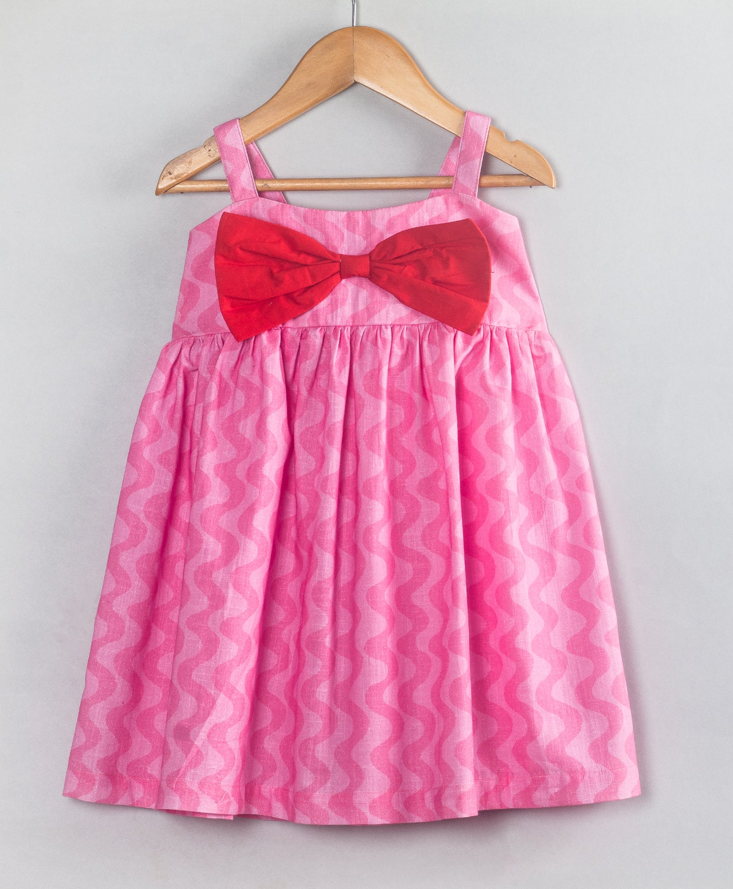 PINK SELF WAVE PRINT DRESS WITH RED BOW