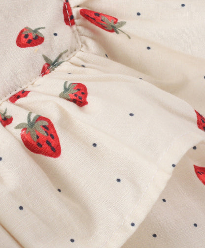 White top with strawberry and dot print with black bow tie at neck