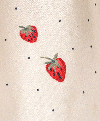 White top with strawberry and dot print with black bow tie at neck