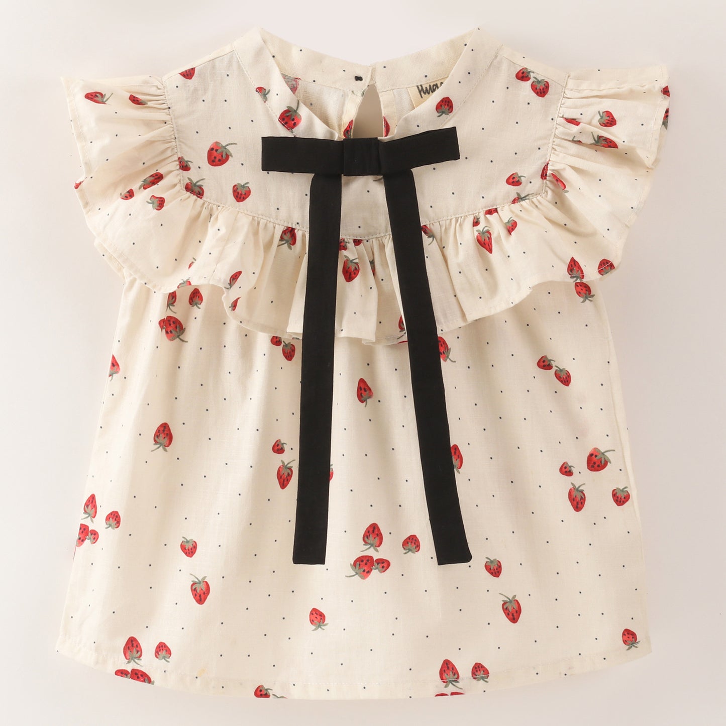 White top with strawberry and dot print with black bow tie at neck